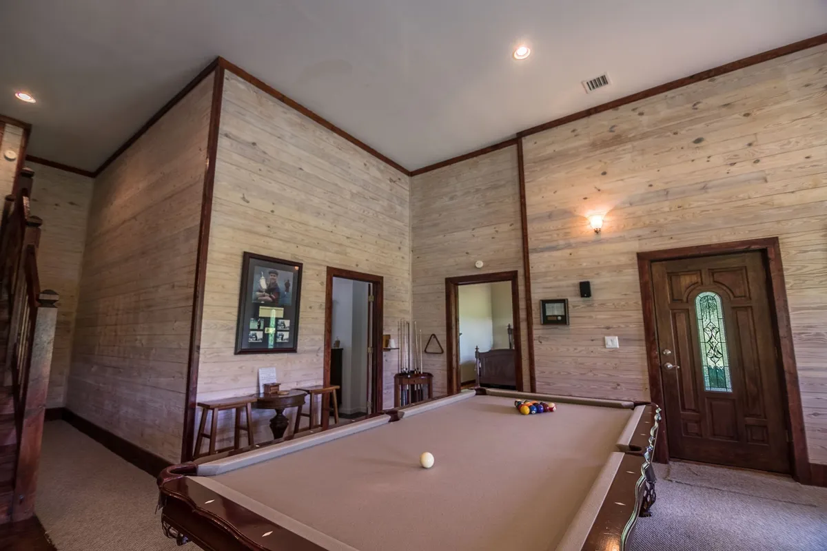 A casual interior game room with a pool table set against wooden walls. The space invites friendly competition, socializing, and relaxation—perfect for movie nights, board games, and tournaments as described in the section.